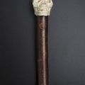 Belle canne à pommeau en ivoire sculpté représentant un crâne humain primitif.