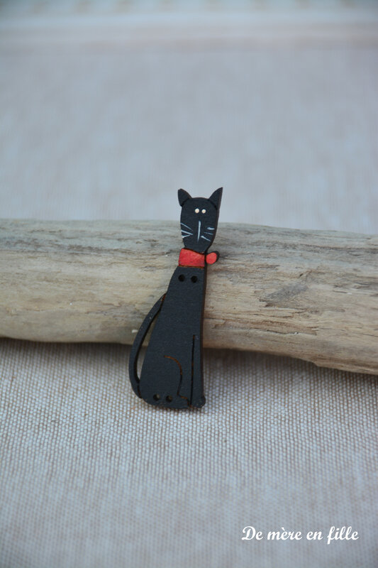 chat noir allongé noeud rouge
