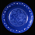 Fritware dish, with decoration cut through a blue slip under a transparent glaze. iran, kerman?; 17th century