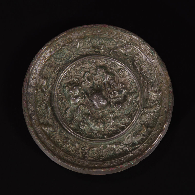 An unusual Chinese 'Beast and Grapes' bronze mirror, Tang dynasty (618-907)